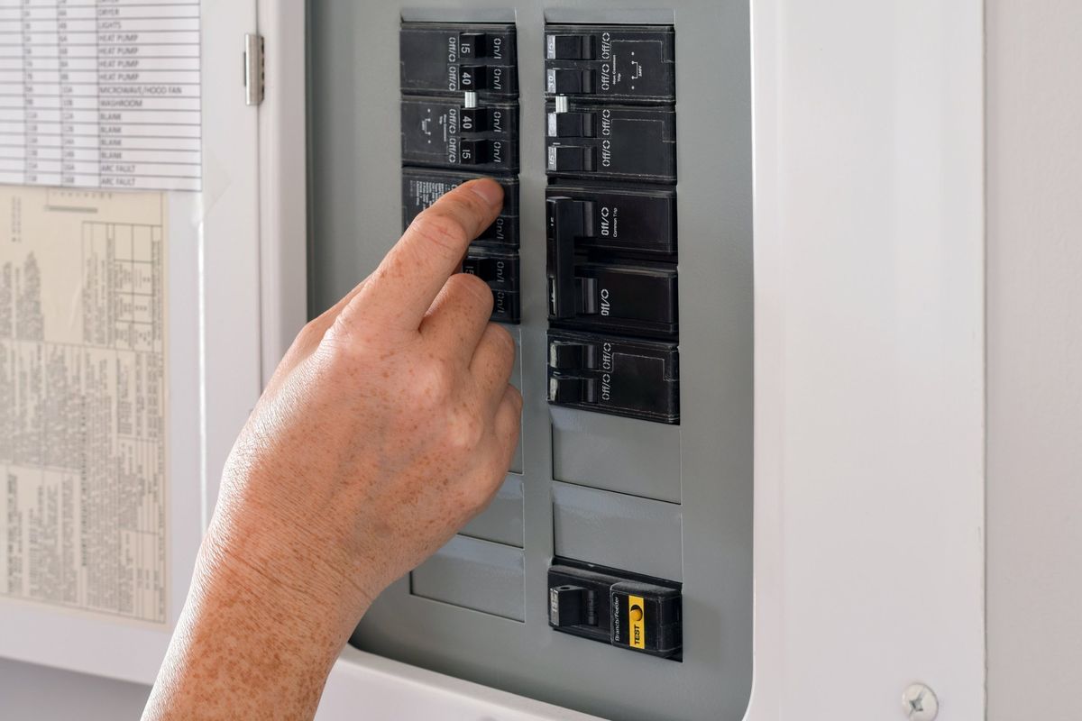 Hand switching a breaker in a labeled residential panel with 15, 30 and 40 amp breakers