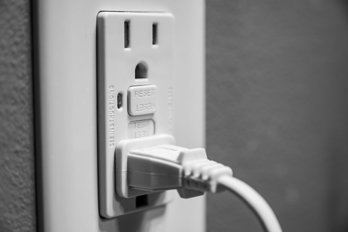 GFCI outlet with TEST and RESET buttons and a cord plugged in