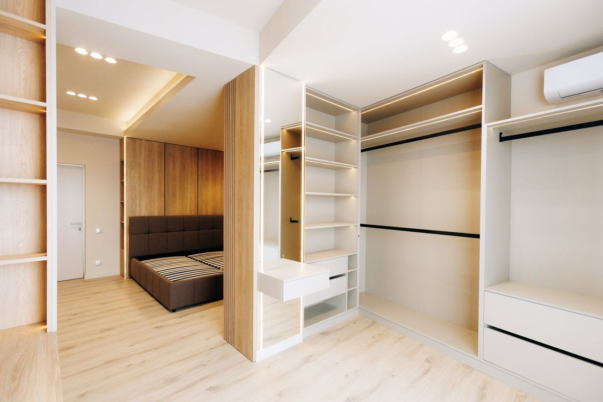 Bedroom and closet with recessed ceiling lights and LED strip lighting in the shelving