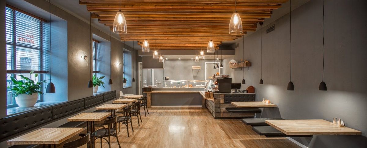 Restaurant dining room with pendant lights over the tables and a lit service counter